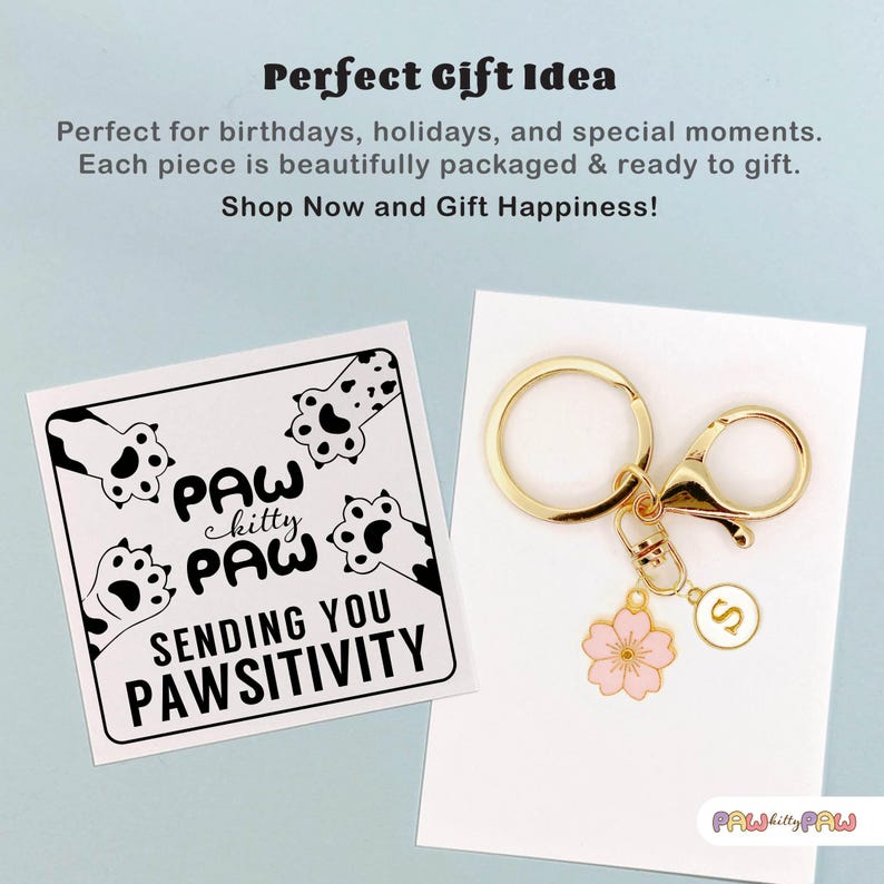 Pink enamel Sakura cherry blossom keychain with gold outline, attached to a gold keyring and an initial charm