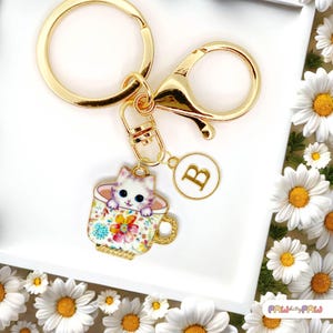 Llavero esmaltado con un lindo gato en una taza de té y monograma personalizado. Divertido llavero kawaii chapado en oro. Moderno dije para bolso - K-A006-8