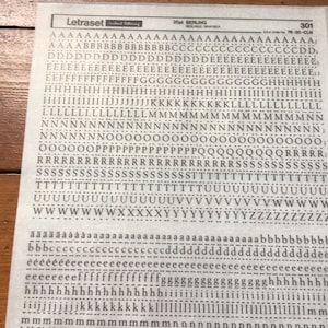 May include: A sheet of Letraset dry transfer lettering in the Berling font, size 20pt. The sheet is filled with rows of letters and numbers, including uppercase and lowercase characters, and punctuation marks. The sheet is labeled with the number 301.