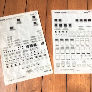 May include: Two sheets of Letraset symbols, featuring computer hardware and related icons. The sheets are white with black illustrations, including computers, monitors, and other electronic components. The text "Letraset symbols" and "Computer Hardware-Micro" are visible.