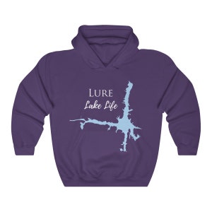 Op de afbeelding: Paarse hoodie met een lichtblauwe omtrek van een meer en de tekst "LURE Lake Life" in wit.