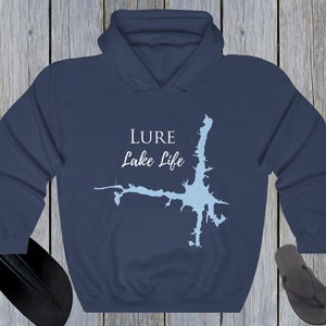 Op de afbeelding: Donkerblauwe hoodie met een witte omtrek van een meer en de tekst "LURE Lake Life" gedrukt op de voorkant.
