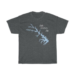 Op de afbeelding: Een donker grijs t-shirt met een lichtblauwe omtrek van Lake Anna en de tekst "Lake Anna Life" in wit.