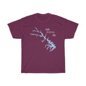 Op de afbeelding: Bordeauxkleurig T-shirt met een lichtblauwe omtrek van Lake Anna en de tekst "Lake Anna Life" in wit.