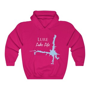 Op de afbeelding: Een roze hoodie met een lichtblauwe omtrek van een meer en de tekst "LURE Lake Life" in wit.