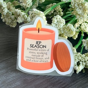 Może przedstawiać: Naklejka z motywem świecy i napisem "IEP SEASON". Świeca jest pomarańczowa z drewnianą pokrywką. Tekst opisuje zapachy stresu, pracy poza godzinami kontraktowymi i nutę łez. Białe kwiaty w tle.