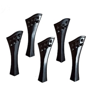 May include: Five black violin tailpieces with a decorative design. The tailpieces are made of wood and have a smooth finish.