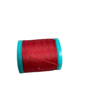 Peut inclure: Une bobine de fil rouge avec une bobine en plastique turquoise.