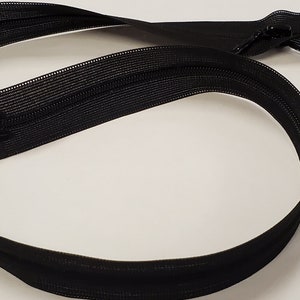 May include: Black zipper tape with a black zipper pull. The zipper tape is approximately 45 cm long.