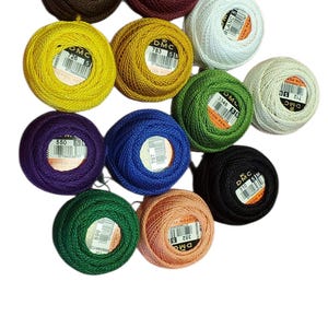May include: A collection of DMC Cotton Perle thread balls in various colors, including brown, burgundy, yellow, white, green, purple, blue, black, green, and peach. Each ball is labeled with a number and the DMC logo.