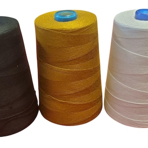 May include: Three spools of thread in black, gold, and white, each with a blue top. The spools are tightly wound, showcasing the thread's texture. Ideal for sewing, embroidery, or other textile crafts.