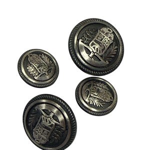May include: Four silver-toned buttons with a raised design. The buttons feature a stylized image of a building with a tree on either side. The buttons have a textured, circular rim.
