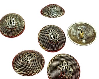 Könnte beinhalten: Eine Sammlung von sechs runden Metallknöpfen mit einer texturierten, punktierten Oberfläche und einem erhabenen, verzierten Monogramm-Design in der Mitte. Jeder Knopf hat einen gedrehten Seilrand und eine Öse auf der Rückseite zur Befestigung.