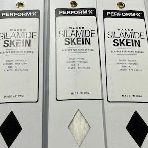 May include: Three rectangular white cards labeled PERFORM-X WAXED SILAMIDE SKEIN. Each card features a diamond-shaped cutout displaying thread in dark navy, white, and black. Text includes size A, 675 yards, reorder codes, and Made in USA.
