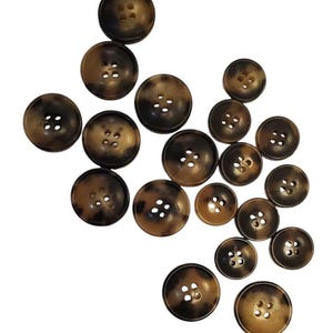 May include: A collection of 15 brown and black buttons, each with four holes. The buttons are made from a mottled material that resembles tortoiseshell.