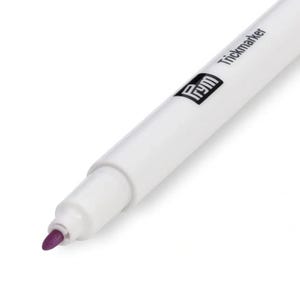 May include: A white Prym Trickmarker with a purple tip. The marker is used for marking fabric.