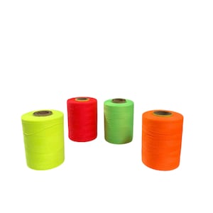 May include: Four spools of brightly coloured thread. The spools are neon yellow, red, green, and orange. Each spool is cylindrical with a cardboard core. The thread is tightly wound around the core.