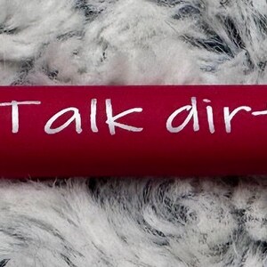 Pu&ograve; includere: Una penna rossa con dettagli argentati e il testo "Talk dirty to me" scritto in bianco sul fusto.