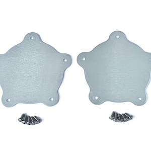 May include: Two silver-colored, star-shaped metal plates with rounded edges and five holes each. Small silver screws are arranged below each plate. The plates have a brushed metal finish and are set against a white background.
