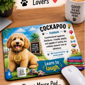 May include: A rectangular mouse pad featuring a golden Cockapoo puppy illustration, a definition of the noun Cockapoo, and the text Learn to laugh. The design includes colourful icons, a stack of books, and a small mug, all set against a grassy background.