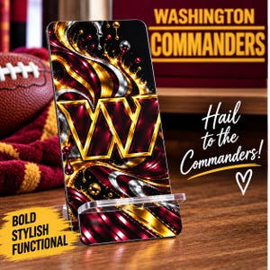 Pode incluir: Um suporte retangular para telemóvel com o logótipo dos Washington Commanders e um design abstrato de espirais em bordeaux, dourado e prateado metálico. O suporte apresenta o texto WASHINGTON COMMANDERS, Hail to the Commanders! e BOLD STYLISH FUNCTIONAL.
