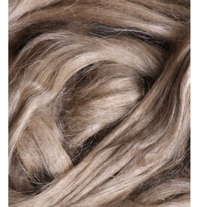 Könnte beinhalten: Nahaufnahme von natürlichen Leinenfasern. Die Fasern sind hellbeige und haben eine weiche, strukturierte Oberfläche.