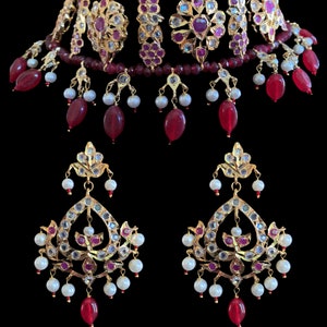 Può includere: Una collana choker in oro e rubino con accenti di perle e perline rosse. Orecchini abbinati con un design simile.