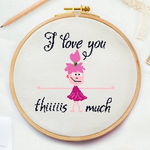 May include: Embroidered hoop art with a pink cartoon character with outstretched arms and the text "I love you this much".