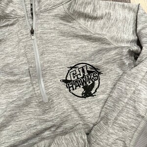 Puede incluir: Sudadera deportiva gris con cremallera negra y un logotipo negro que dice "C.H. HAWKS" con un diseño de pájaro.