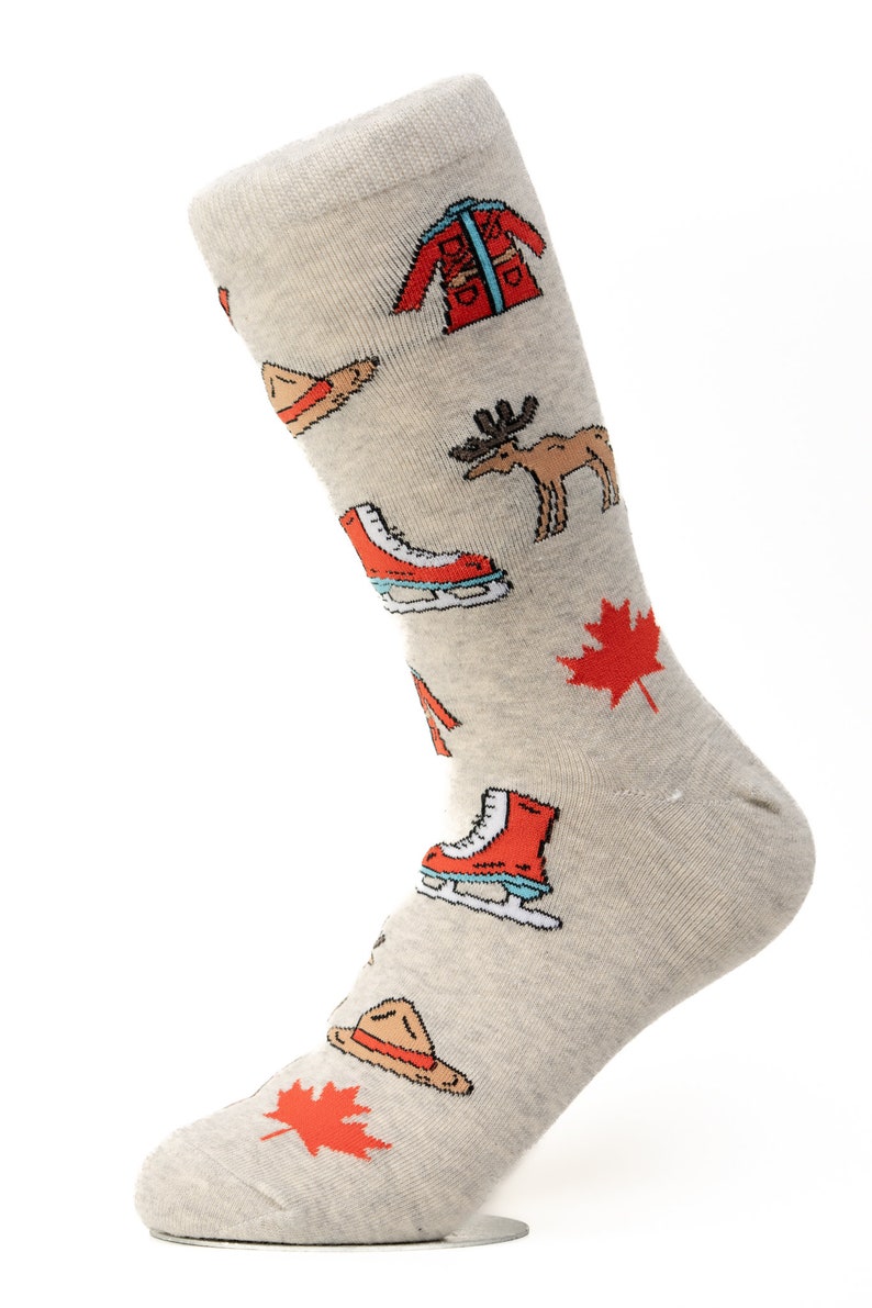 May include: A pair of gray socks with a variety of Canadian-themed illustrations, including a red maple leaf, a red and white toque, a red and white parka, a red ice skate, a moose, and a park ranger hat.