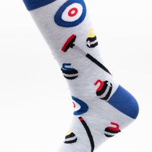 May include: A pair of grey socks with a blue cuff and a pattern of curling stones, brooms, and targets.