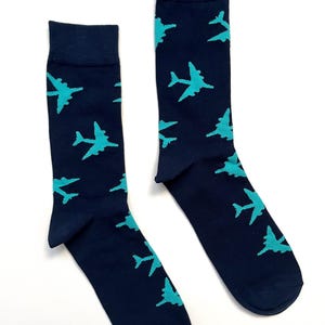 May include: A pair of dark blue socks with a teal airplane pattern.