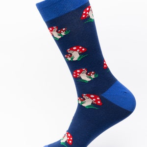 Könnte beinhalten: Eine blaue Socke mit einem roten und weißen Pilzmuster. Die Socke hat einen blauen Bund und eine blaue Spitze.