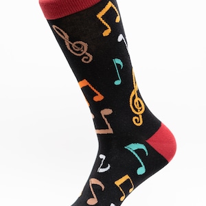 May include: Black socks with a red cuff and a colorful musical note pattern.