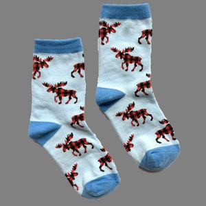 Könnte beinhalten: Ein Paar blaue und weiße Socken mit einem roten und schwarzen karierten Elchmuster.