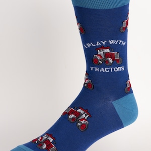 May include: Blue socks with a repeating pattern of red and white tractors. The socks have a blue heel and toe, and the text "I PLAY WITH TRACTORS" is printed on the side.