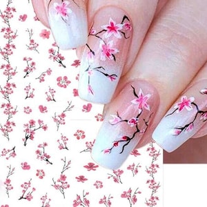 May include: A sheet of nail art stickers with a pink and white cherry blossom design. The stickers are perfect for adding a touch of elegance to your nails.