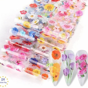 Könnte beinhalten: Ein Set bunter Blumen-Nagelfolien. Die Folien zeigen eine Vielzahl von Blumen, darunter Rosen, Gänseblümchen und Sonnenblumen. Die Folien sind so konzipiert, dass sie mit einem klaren Überlack auf die Nägel aufgetragen werden können.
