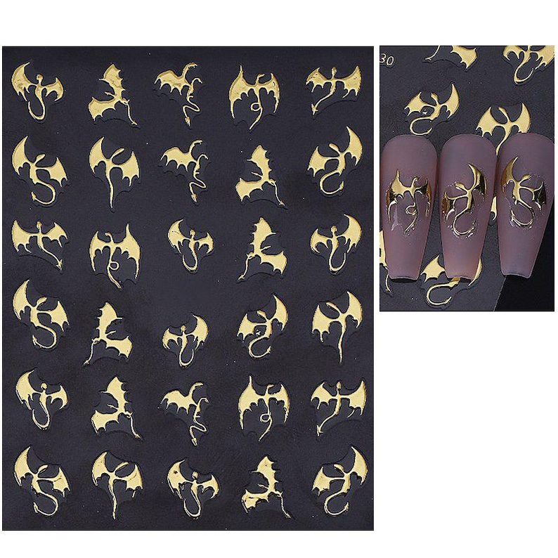 May include: Sheet of nail art stickers featuring gold and black dragon designs. The stickers are in various poses and sizes, with some applied to painted nails. The dragons have detailed wings and serpentine bodies, perfect for a gothic or fantasy theme.