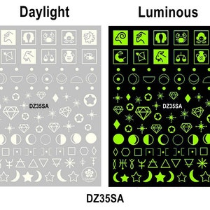 Pu&ograve; includere: Un foglio di adesivi per unghie luminescenti con una variet&agrave; di disegni, tra cui segni zodiacali, lune, stelle e forme geometriche. Gli adesivi sono mostrati sia alla luce del giorno che in condizioni luminose. Il testo "DZ35SA" appare sul foglio.