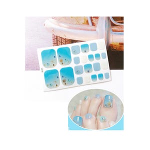 May include: A sheet of blue and white toe nail stickers with a seashell and starfish design. The stickers are shown applied to a person's toes.