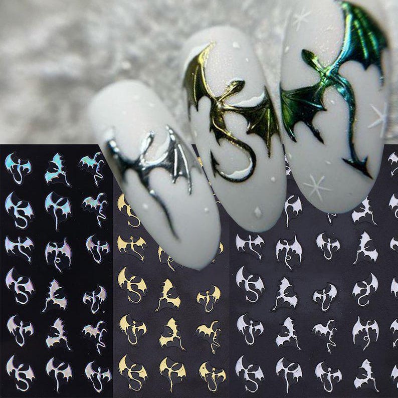 May include: Nail art stickers featuring dragon designs in silver, gold, and iridescent finishes. The stickers are displayed on a black background, with several dragon designs on white nail polish.