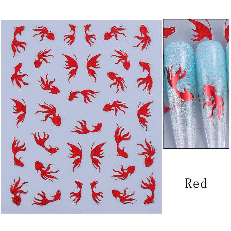 May include: Sheet of red fish nail art stickers. The stickers feature various fish designs, including full fish and fish silhouettes. The image also shows two nail tips with a red fish design on a blue and silver background. The word "Red" is in the bottom right corner.