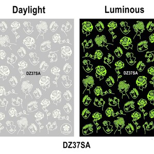 Pu&ograve; includere: Due fogli di adesivi per l'arte delle unghie con un motivo di volti e rose. Il foglio a sinistra mostra il design in bianco su uno sfondo grigio. Il foglio a destra mostra il design in verde neon su uno sfondo nero. Il testo "DZ37SA" appare su entrambi i fogli.