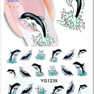 May include: A sheet of nail art stickers featuring a repeating pattern of black and white dolphins jumping out of turquoise blue waves. The text "YG1239" is printed on the sheet.