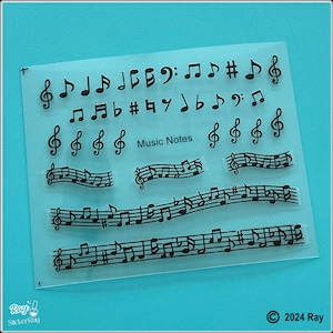 May include: Clear sheet of transparent plastic with black musical notes and symbols. The sheet includes individual notes, sharps, flats, and a treble clef. There are also several lines of musical notes with a staff.