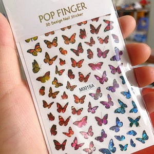 May include: A sheet of 3D nail stickers featuring colorful butterfly designs. The stickers are arranged in rows and columns on a white background. The text "POP FINGER 3D Design Nail Sticker" is printed at the top of the sheet. The code "M001SA" is printed in the center of the sheet.
