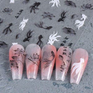 May include: Nail art stickers featuring a koi fish and lotus flower design in black and white. The stickers are applied to five artificial nails with a pink and white gradient. Some nails have Chinese characters.