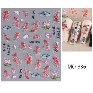 May include: Nail art stickers featuring red koi fish, pink lotus flowers, and green lily pads on a gray background. The stickers also include Chinese characters and the product code "MO-336".