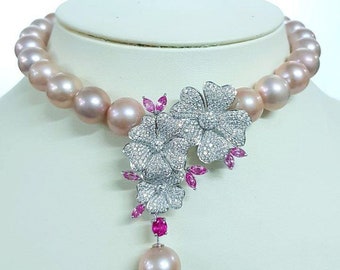 May include: A pearl necklace with a silver pendant featuring a cluster of flowers with pink gemstones and a single pearl drop.